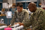 U.S. Navy Hospital Corpsman Chief Petty Officer Antares Zongo, material management equipment division leading chief petty officer at Naval Medical Center San Diego, provides instruction to Hospital Corpsman 2nd Class Arielle Sagum, biomedical equipment technician, at NMCSD, May 19. NMCSD employs more than 5,500 active-duty military personnel, civilians, and contractors in Southern California to deliver exceptional care afloat and ashore. (U.S. Navy photo by Mass Communication Specialist 3rd Class Jason Afable)