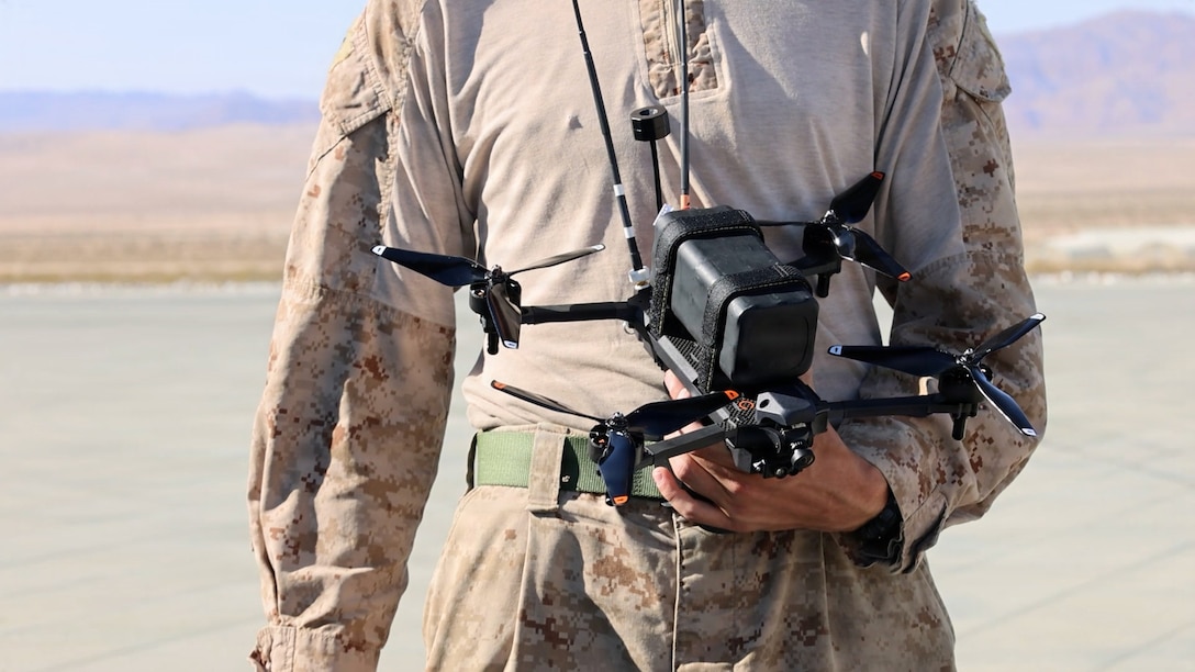 A U.S. Marine with 3rd Light Armored Reconnaissance Battalion, 1st Marine Division performs a systems check during a first person view unmanned aircraft system integration exercise with a UH-1Y Venom, assigned to Marine Light Attack Helicopter Squadron (HMLA) 169, Marine Aircraft Group 39, 3rd Marine Aircraft Wing, at Marine Corps Air Ground Combat Center, Twentynine Palms, California, May 13, 2026. The collaborative exercise allowed Marines to determine the feasibility of using FPV UAS from an aircraft and evaluate how to best integrate them to increase combat capabilities and lethality. (U.S. Marine Corps photo by Sgt. Symira Bostic)