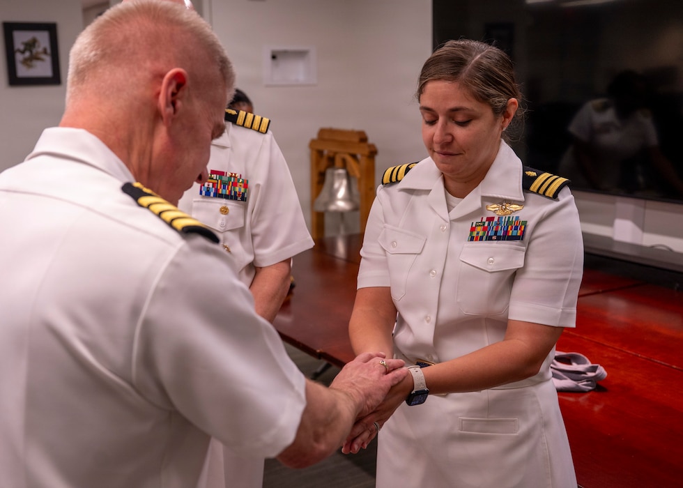 260513-N-IX644-1078 (May 13, 2026) FALLS CHURCH, Va. U.S. Navy Lt. Cmdr. Alainna Crotty, a native of Harrisburg, Pennsylvania, has her hands blessed by Capt. William Hlavin, the Navy Medicine Enterprise chaplain, during a celebration for the 118th birthday of the Navy Medicine Nurse Corps at the Defense Health Headquarters, May 13. The Blessing of the Hands is a tradition held during National Nurses Week to honor the compassionate care provided by medical professionals. The ceremony symbolizes the vital importance of the human touch in healing and offers a moment of spiritual renewal for those supporting the DoW medical mission. Established on May 13, 1908, the Navy Nurse Corps has a rich legacy of providing exceptional, compassionate care to Sailors, Marines, and their families around the globe, ensuring the health and readiness of the force in both peacetime and conflict. (U.S. Navy photo by Mass Communication Specialist 2nd Class Sasha Ambrose)