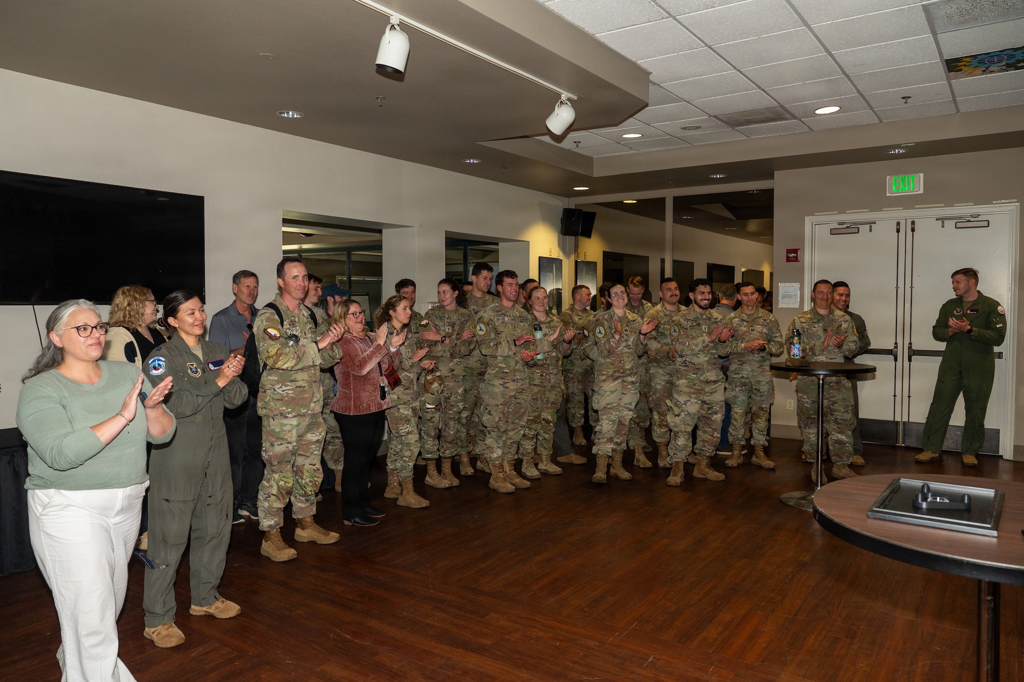 A group of people clap inside a room.