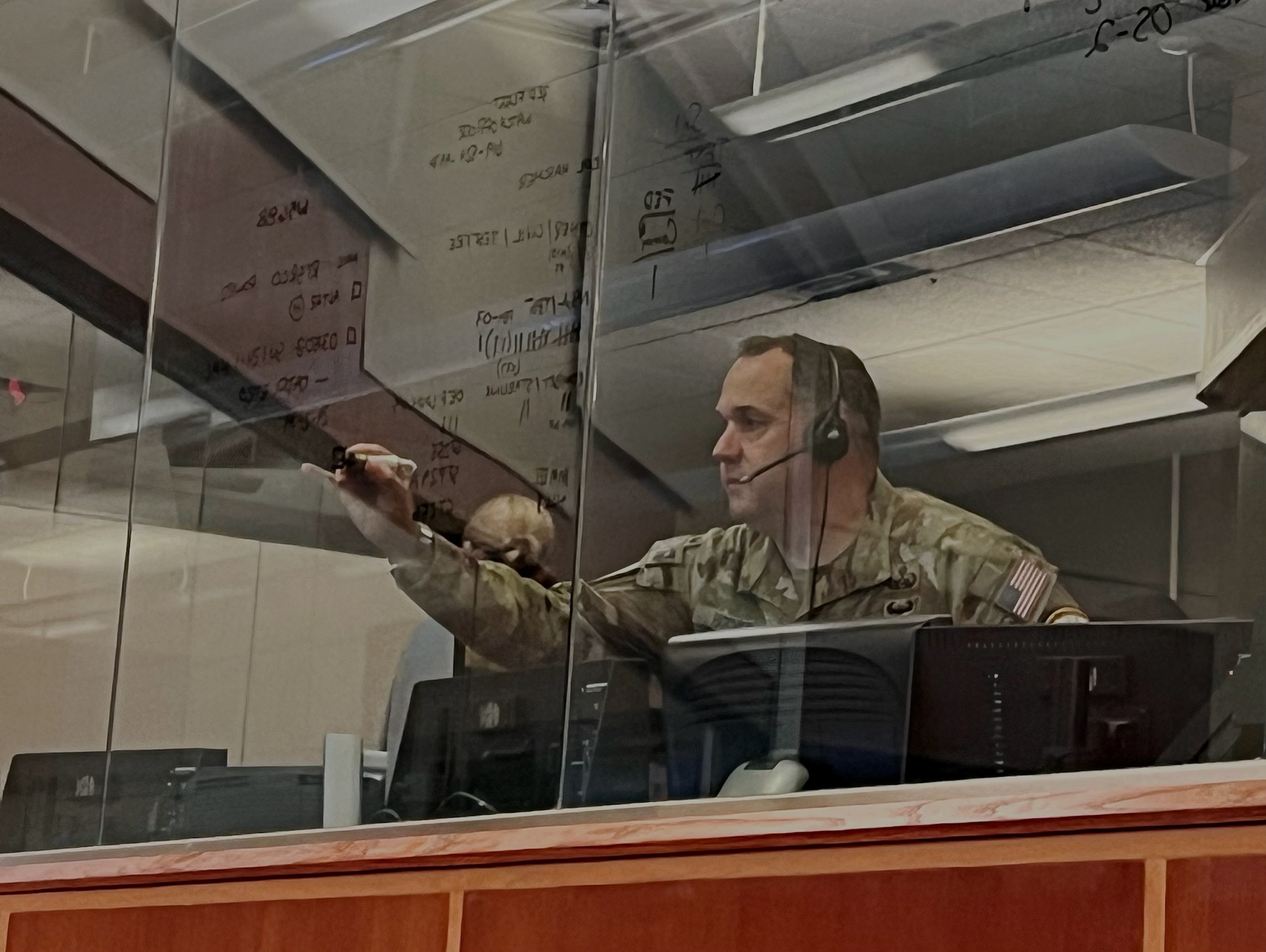 U.S. Space Force Col. Dorian Hatcher writes operational notes on a window in the Western Range Operations Control Center during the May 20 unarmed Minuteman III ICBM test at Vandenberg Space Force Base.