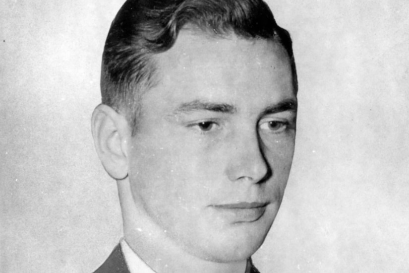 A man wearing an Army dress uniform poses for a photo.