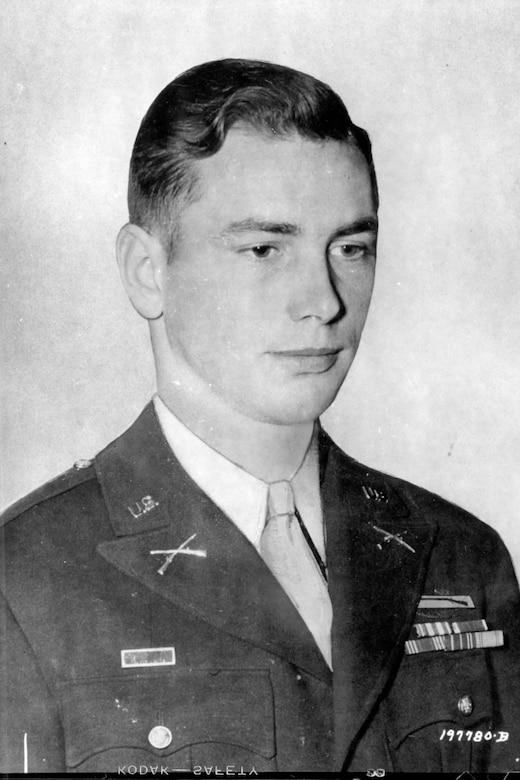 A man wearing an Army dress uniform poses for a photo.