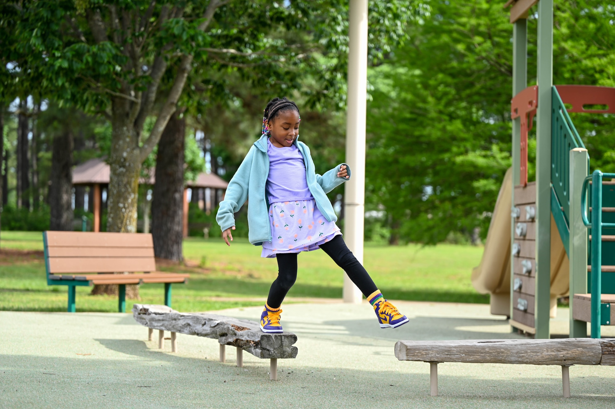 A child walks across a balance beam.