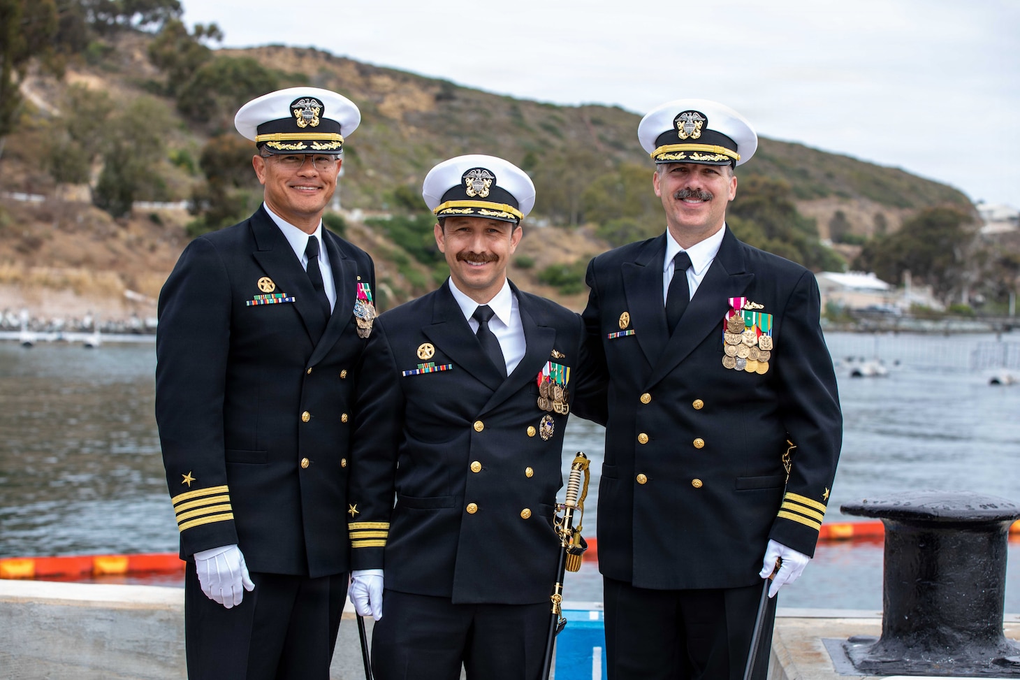 NAVAL BASE POINT LOMA, Calif. (May 15, 2026) – From left to right, Capt. Phillip Sylvia Jr., commander, Submarine Squadron 11, Cmdr. Miguel Recalde, commanding officer, Los Angeles-class fast-attack submarine USS Santa Fe (SSN 763), and Cmdr. Eric Knepper pose for a photo following the change of command ceremony for Santa Fe onboard Naval Base Point Loma, May 15, 2026. During the ceremony, Knepper was relieved by Recalde as commanding officer of Santa Fe. Santa Fe is assigned to Commander, Submarine Squadron 11, home to four Los Angeles-class fast-attack submarines which are capable of supporting various missions, including anti-submarine warfare, anti-ship warfare, strike warfare and intelligence, surveillance and reconnaissance. (U.S. Navy photo by Mass Communication Specialist 2nd Class Rashan Jefferson)