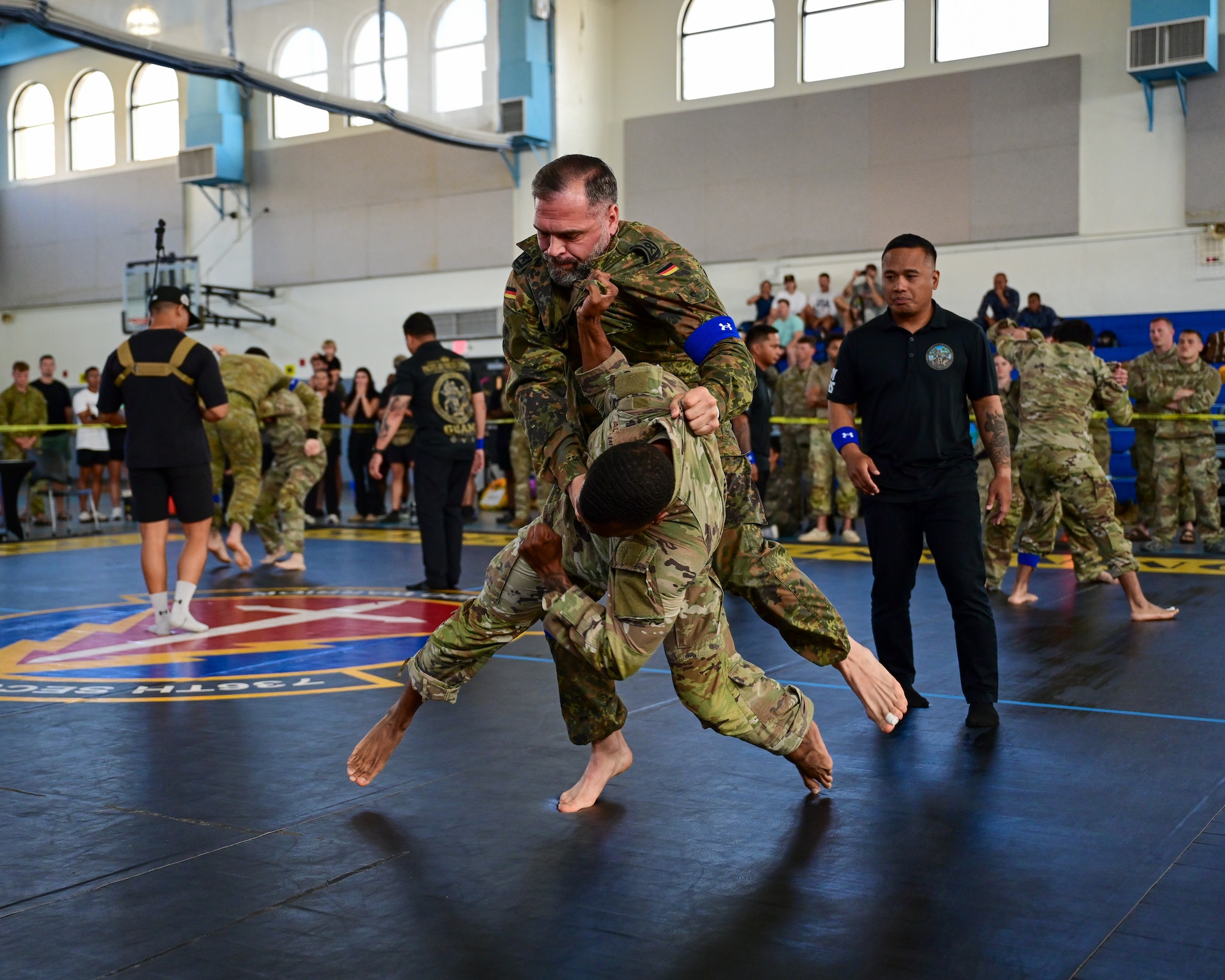 A U.S. Security Forces Airman grapples a German Bundeswehr soldier over his shoulder during the combatives portion of Pacific Air Force’s 9th Annual Advanced Combat Skills Assessment Competition at Andersen Middle School, Andersen Air Force Base, Guam, May 22, 2026.
