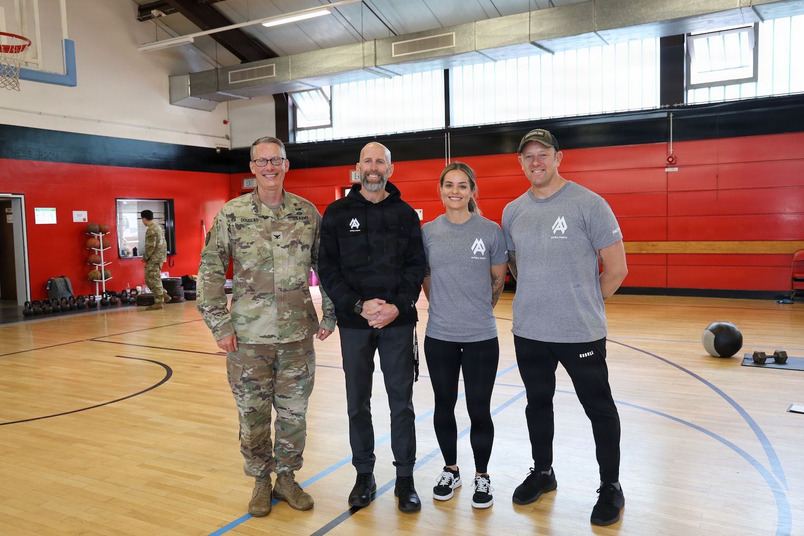 Col. Charles Douglas deputy commander officer Landstuhl Regional Medical center pose with Marcus Mclean, program manager, Kristin Fusilier and from the Apex Path CrossFit gym after receiving a commander’s coin on May 18 at the LRMC  fitness center. The competition served as the culminating event of the month-long Mental Health Awareness Month observance.