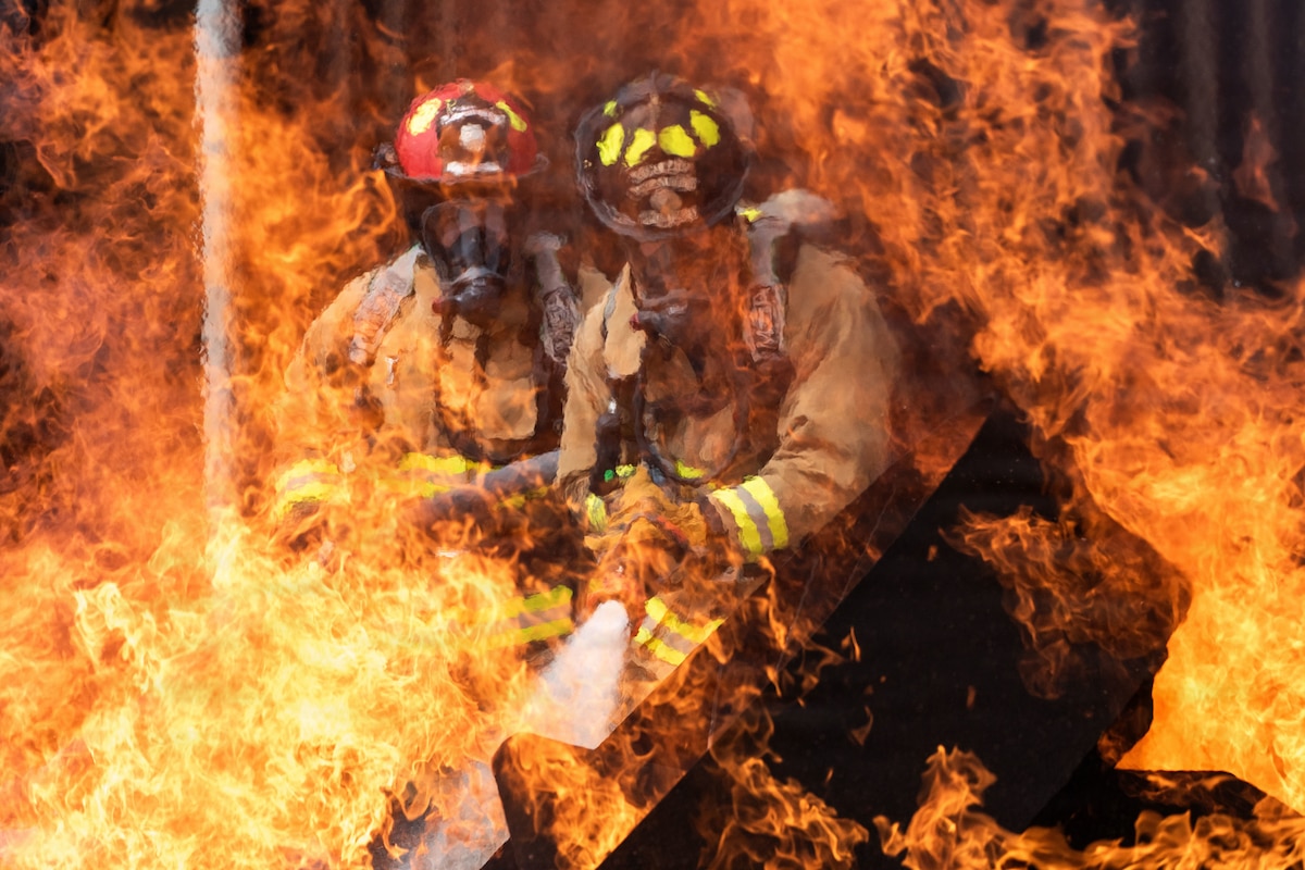 Airmen assigned to the 60th Civil Engineer Squadron extinguish a simulated aircraft fire during live-fire training at Travis Air Force Base, Calif., May 6, 2026. The joint training event, held May 6-8, ensured firefighters maintained Federal Aviation Administration certification while strengthening partnerships between military and civilian emergency responders. (U.S. Air Force photo by Kenneth Abbate)