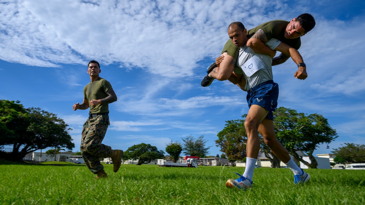 Master Sgt. Austin Tyler, 18th Logistics Readiness Squadron superintendent of ground transportation, carries a fallen teammate during a simulated maneuver-under-fire exercise at the Warrior Gauntlet at Kadena Air Base, Japan, May 8, 2026. The event emphasized teamwork, resilience and combat readiness under pressure.