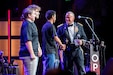 Lt. Gen. Robert Harter (right), 35th Chief of Army Reserve and 10th Commanding General, U.S. Army Reserve Command, shakes the hand of future soldier Ulysses McMahan, one of six future soldiers who took the oath of enlistment on stage during the Grand Ole Opry's annual 