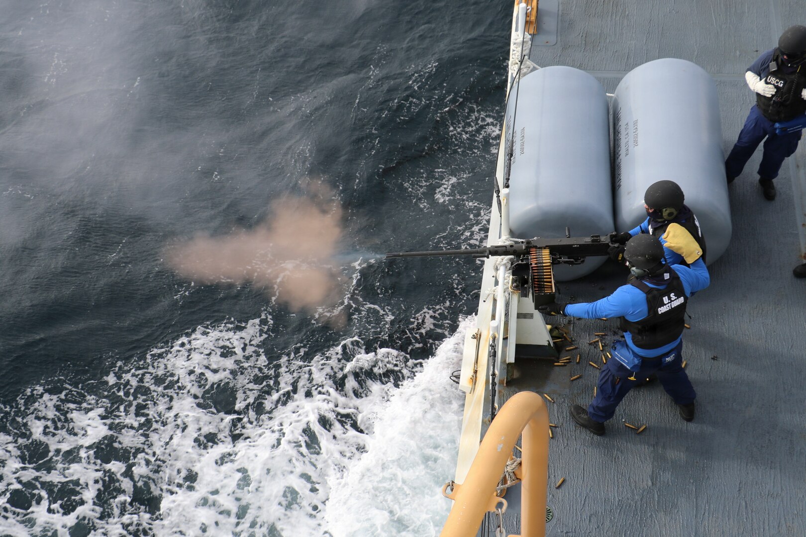 U.S. Coast Guard crew members, assigned to U.S. Coast Guard Cutter Waesche (WMSL 751) fire a .50 caliber machine gun during a gunnery exercise aboard the cutter in the Bering Sea, April 1, 2026. The Waesche crew continues to maintain and increase capabilities to ensure a proficient crew while underway. (U.S. Coast Guard photo by Petty Officer 3rd Class Lillian Escobar)
