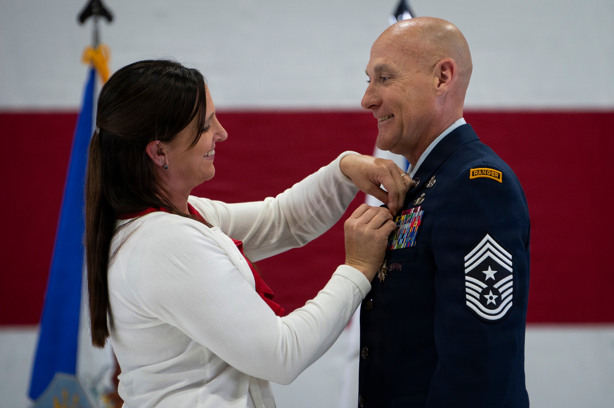 Military spouse places a pin on a retiring Airman