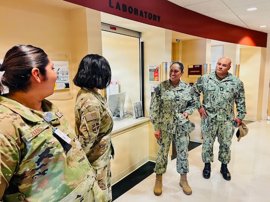 Capt. Janiese Cleckley (center-right) and Master Chief Richard Moreno (right) meet with staff assigned to the 412th Medical Group during a tour of medical facilities at Edwards Air Force Base on May 14, 2026. Leaders from Naval Hospital Twentynine Palms visited Edwards AFB to strengthen cross-service collaboration, improve interoperability, and identify new opportunities to enhance medical readiness and healthcare delivery across the Mojave Desert region. (Courtesy photo)