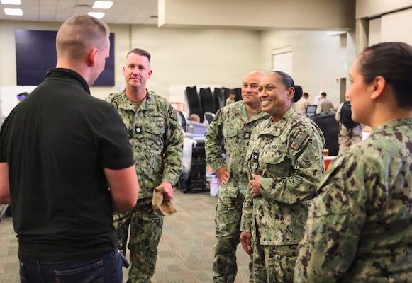 Capt. Janiese Cleckley (center-right), commanding officer of Navy Medicine Readiness and Training Command Twentynine Palms and director of Naval Hospital Twentynine Palms, Master Chief Richard Moreno (center), command master chief, interim deputy director Cmdr. William “Bill” Lawson (center-left) and Hospital Corpsman 1st Class April Million (right) meet with staff from the Armed Services Blood Program during a record-breaking blood drive at Marine Corps Air Ground Combat Center Twentynine Palms, May 6, 2026. The blood drive collected 117 units of blood in support of military operations overseas, setting a new installation record for collections during a single event. (U.S. Navy photo by Christopher Jones, NH/NMRTC Twentynine Palms public affairs officer)