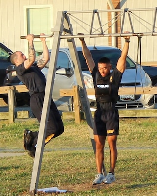 Hospital Corpsman 3rd Class Mitchell McGinnis, left, and Lieutenant Timothy Mohammad, assigned to Navy Medicine Readiness and Training Command (NMRTC) Patuxent River, perform pull-ups during the command’s monthly physical training event at the Naval Air Station Patuxent River Drill Hall Field.

The command took on the 'Murph' challenge to honor the upcoming Memorial Day weekend and pay tribute to Navy SEAL Lt. Michael Murphy, who was killed in action in Afghanistan in 2005 and posthumously awarded the Medal of Honor.

While the command structured the event to allow for team-based scaling, Mohammad opted to tackle the punishing workout individually while wearing a 20-pound weighted vest. To complete the full, traditional challenge solo, he pushed through a 1-mile run, 100 pull-ups, 200 push-ups, 300 squats, and a final 1-mile run, embodying the rigorous standard of the original tribute and demonstrating the command's commitment to physical readiness.