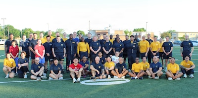 Service members assigned to Navy Medicine Readiness and Training Command (NMRTC) Patuxent River gather for a group photo at the Naval Air Station Patuxent River Drill Hall Field following the completion of the command’s monthly physical training event.

The command took on the 'Murph' challenge—consisting of a 1-mile run, 100 pull-ups, 200 push-ups, 300 squats, and a final 1-mile run—to honor the upcoming Memorial Day weekend and pay tribute to Navy SEAL Lt. Michael Murphy, who was killed in action in Afghanistan in 2005 and posthumously awarded the Medal of Honor.

To foster unit cohesion and ensure full participation, the grueling workout was modified into a team event, breaking Sailors into groups to partition the repetitions across a collective unit.