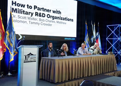 SAN ANTONIO – (May 19, 2026) – Dr. Matthew Solomon (left), science program manager, assigned to Naval Medical Research Unit (NAMRU) San Antonio, participated in “How to Partner with Military Research & Development Organizations” panel during the annual AIM Health R&D Summit held at the Henry B. Gonzalez Convention Center. Joining Solomon were (left to right) Dr. Tammy Crowder, director, Office of Research and Technology Application, U.S. Army Institute of Surgical Research; Bob Charles, chief of Medical Research Collaboration Law, Defense Health Agency; and Dr. Scott Walter, director, Tech Transfer, U.S. Air Force 59th Medical Wing. Designed to promote cross-sector collaboration in the development of life-saving battlefield technologies, the one-day summit brings together top innovators from academia, industry, and the military to accelerate the research, development, and commercialization of transformative medical technologies. Collaborating and working alongside a wide range of research and development partners keeps Navy Medicine Research & Development (NMR&D) abreast of best practices and advances in medical knowledge. NAMRU San Antonio, part of NMR&D conducts gap-driven combat casualty care, craniofacial, and directed energy research in support of Navy, Marine Corps and joint U.S. warfighter health readiness and lethality while engaged in routine and expeditionary operations. (U.S. Navy photo by Burrell Parmer, NAMRU San Antonio Public Affairs/Released)