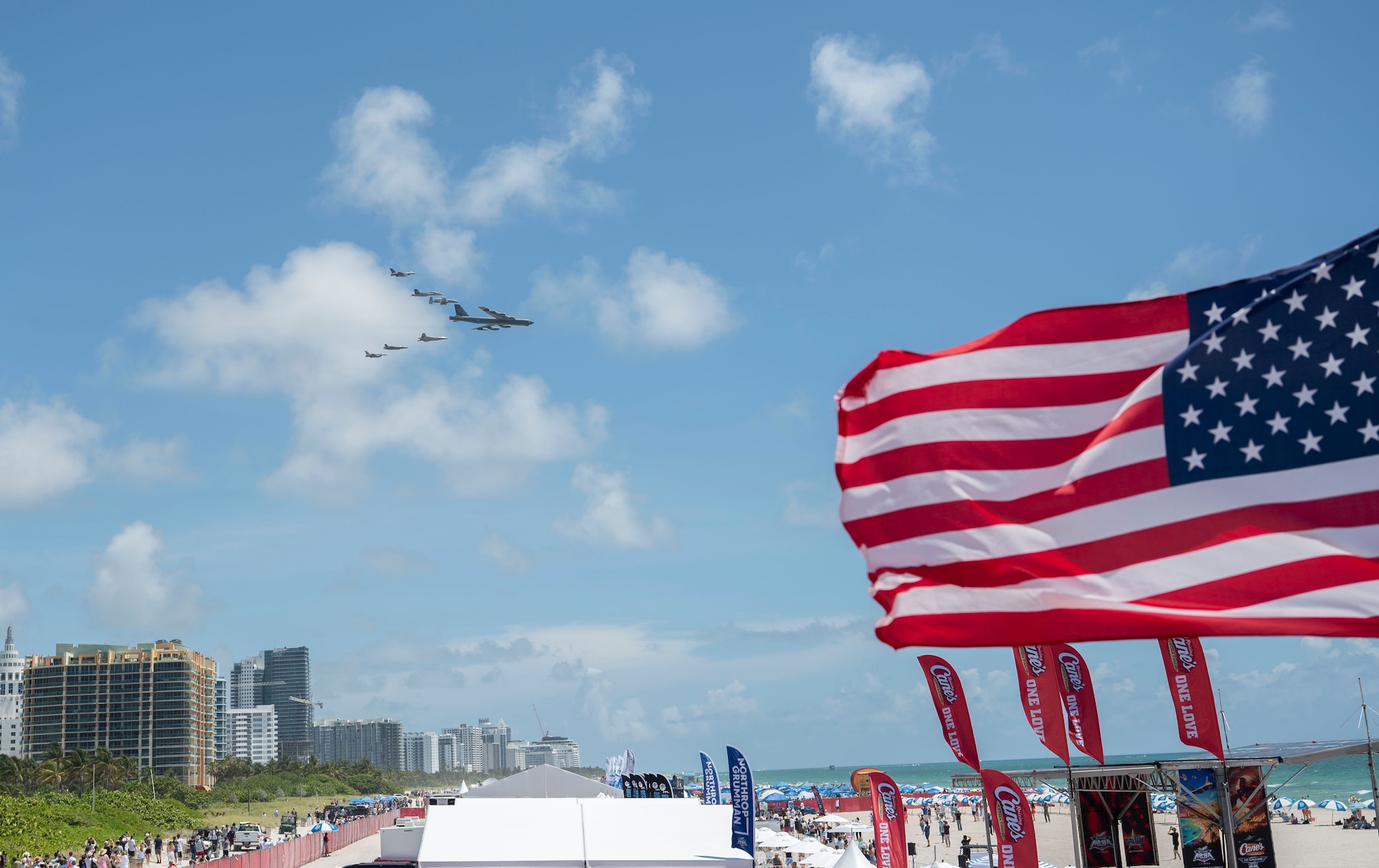 Aircraft flying over crowd on beach