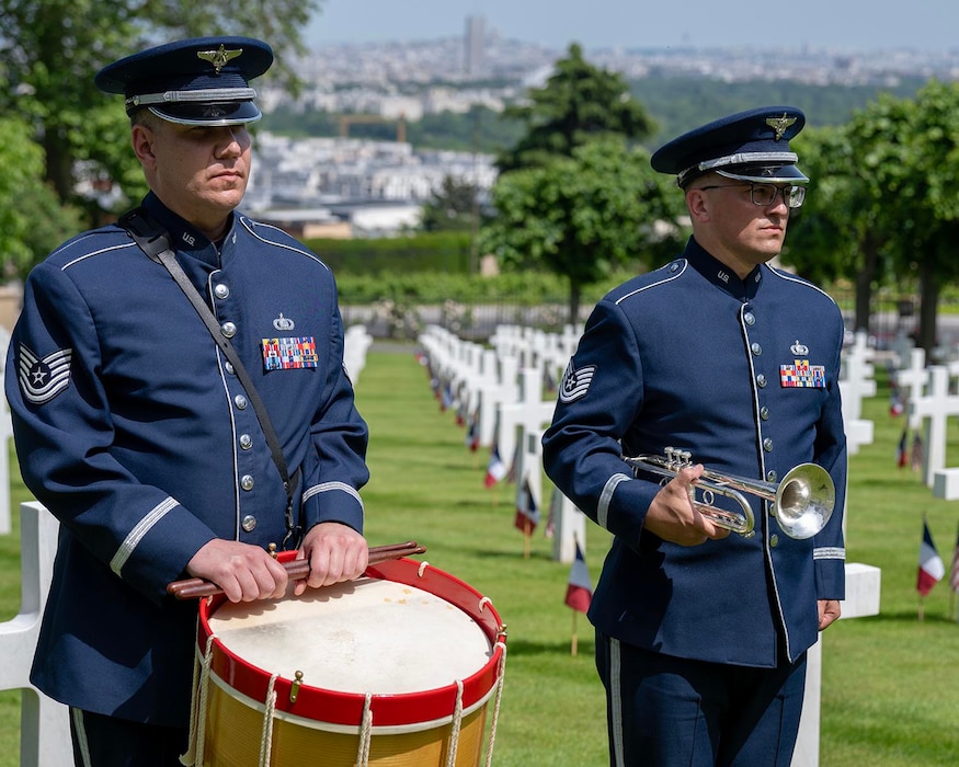 U.S. Air Force Tech. Sgt. Andy Wendzikowski, left, drummer, and Tech. Sgt. Nick Del Villano, trumpeter, both assigned to the U.S. Air Forces in Europe - Air Forces Africa Band, perform during a Memorial Day ceremony held at the Suresnes American Cemetery and Memorial, Suresnes, France, May 24, 2026.