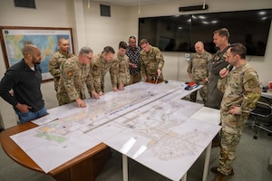 Airmen move pieces around on a map.