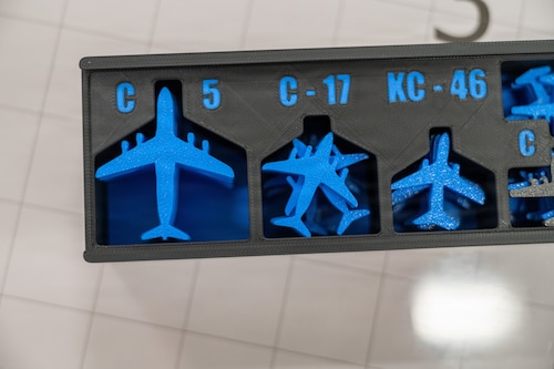 Blue 3D-printed aircraft pieces are displayed inside of a box.