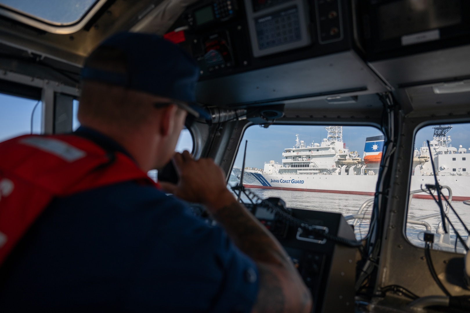 U.S. Coast Guard Petty Officer 1st Class Justin Neeper, executive officer U.S. Coast Guard Station Port Angeles, communicates over the radio with Japan Coast Guard vessel Itsukushima during a joint search and rescue exercise in the Strait of Juan de Fuca, May 21, 2026.