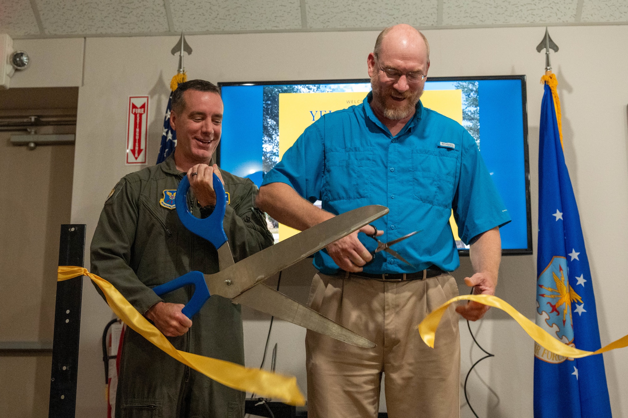 U.S. Air Force Col. Ryan Stallsworth, 7th Bomb Wing deputy commander, and Walter Nicolds, Dyess Memorial Museum and Linear Air Park curator, cut a yellow ribbon during a dedication ceremony inside the Dyess Memorial Museum at Dyess Air Force Base, Texas, May 21, 2026. The ribbon cutting signified the official opening of the static A-10 Thunderbolt II and F-16 Fighting Falcon displays, marking the completion of a three-year construction effort at the Dyess Linear Air Park. (U.S. Air Force photo by Airman 1st Class William Neal)