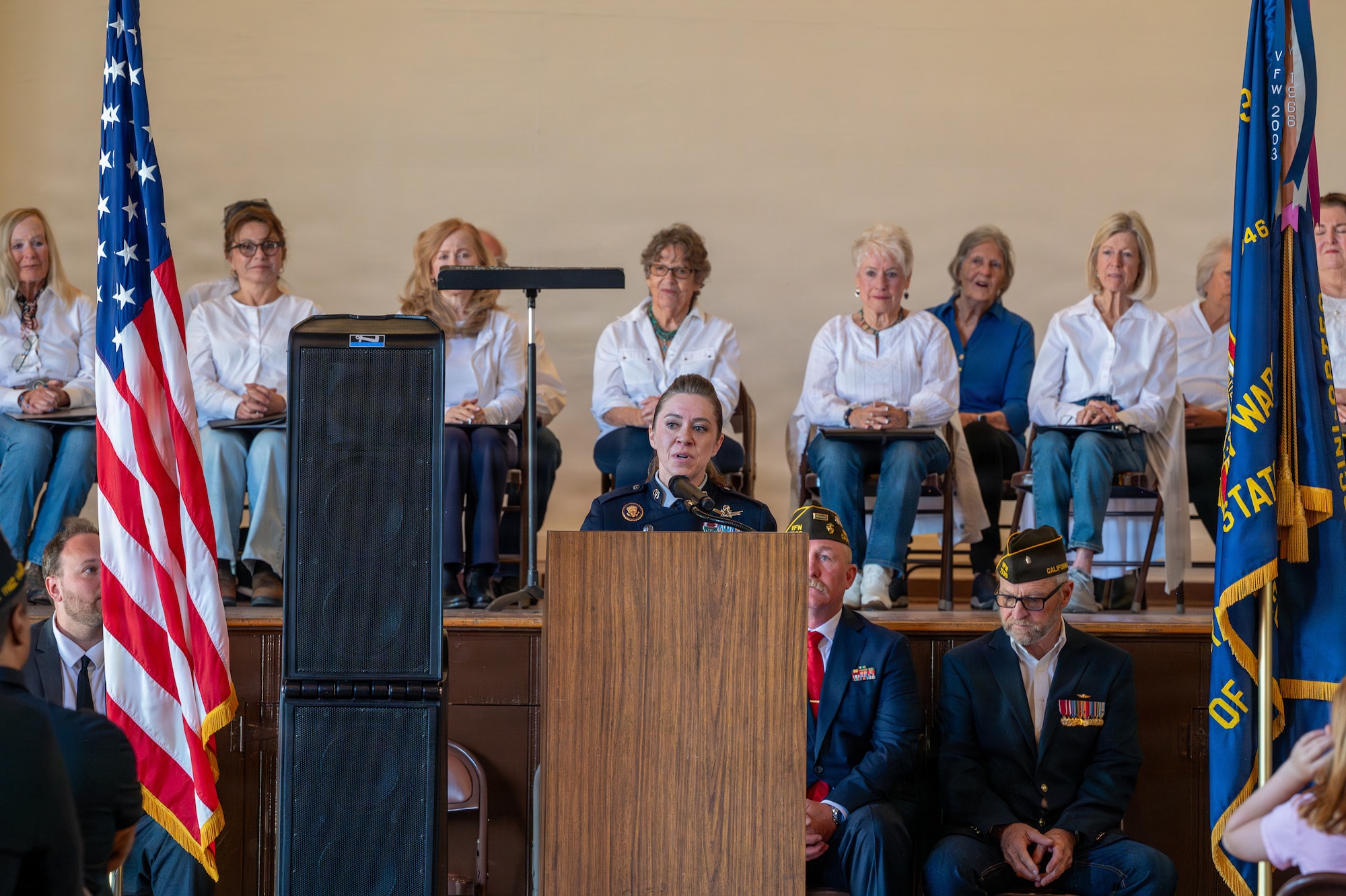 A person stands and speaks behind a podium.