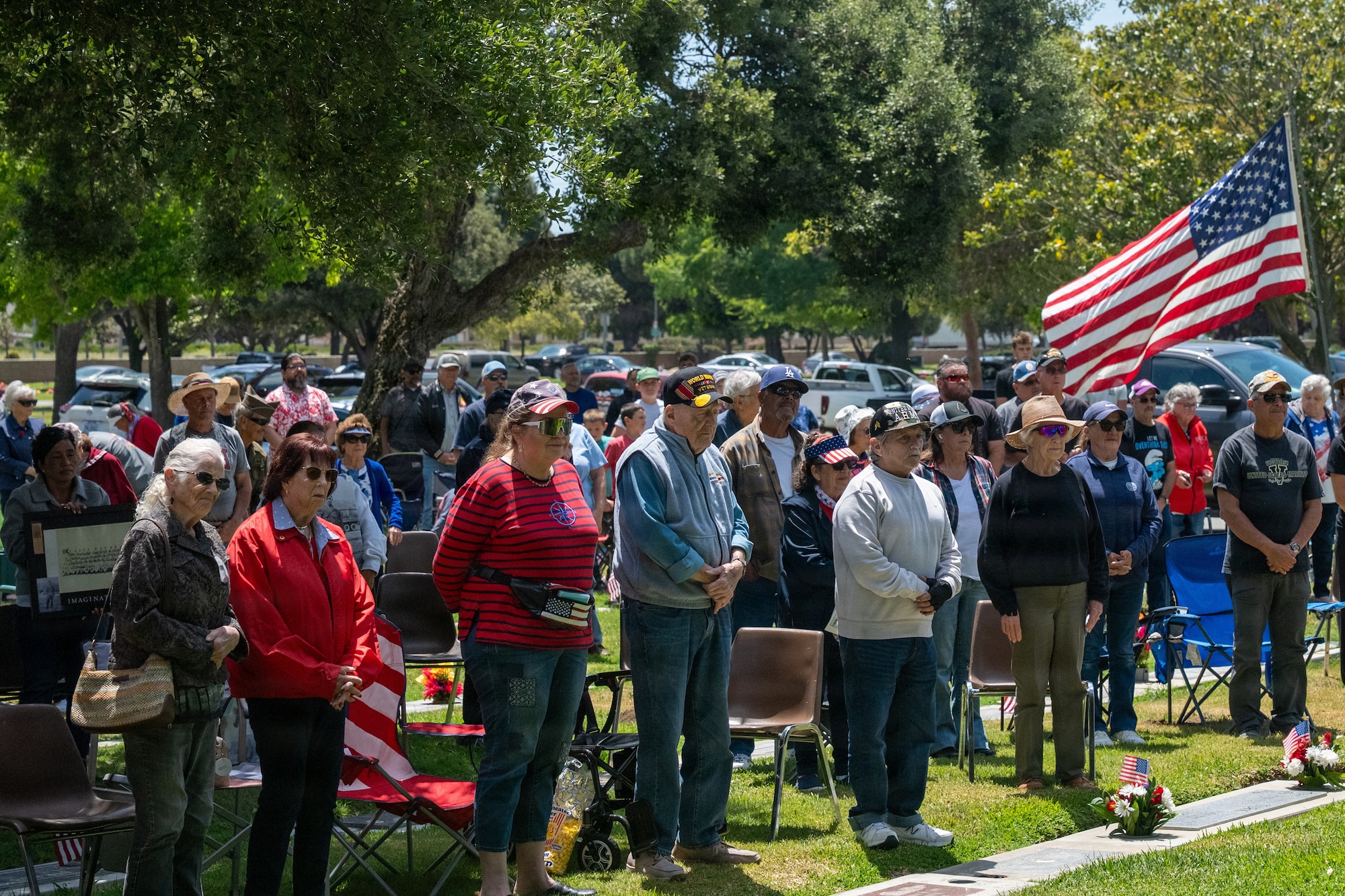 Veterans, family, and friends standing at a ceremony for memorial day.
