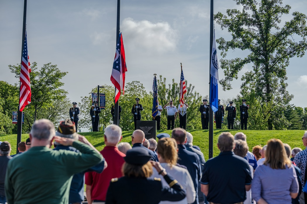 Attendees at a Memorial Day ceremony salute the American flag during the national anthem in Centerville, Ohio.
