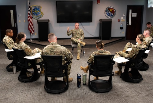 Airmen sit in semi-circle listening to CMSAF
