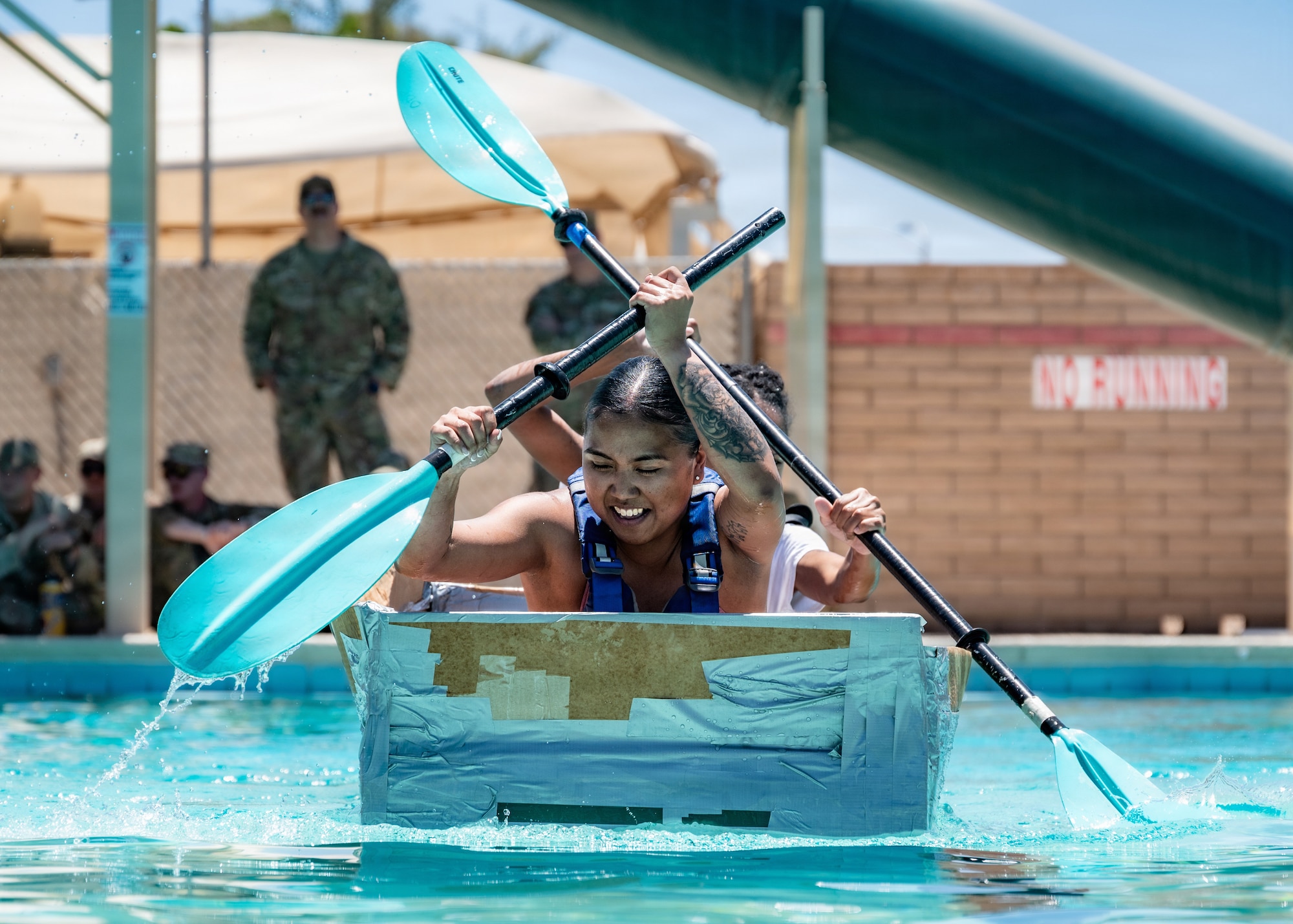 U.S. Air Force Senior Airman Mary Ramos, 56th Civil Engineer Squadron operations management journeyman, propels her cardboard craft toward the end of the course during the annual 56th CES Boat Regatta at Luke Air Force Base, Arizona, May 20, 2026.