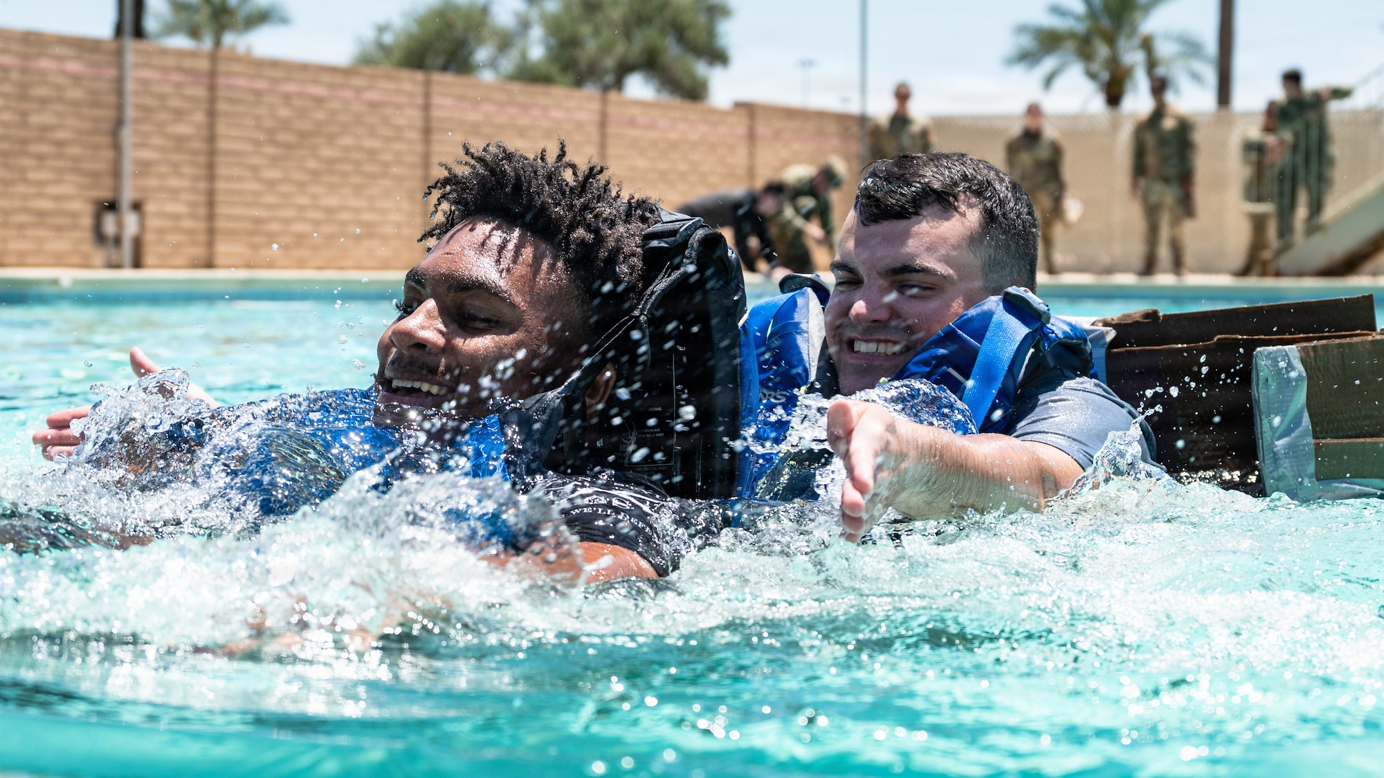 U.S. Air Force Airmen 1st Class Kyran Houston, left, and Charles George, 56th Civil Engineer Squadron heavy equipment and pavements technicians, swim toward the finish line during the annual 56th CES Boat Regatta, at Luke Air Force Base, Arizona, May 20, 2026.
