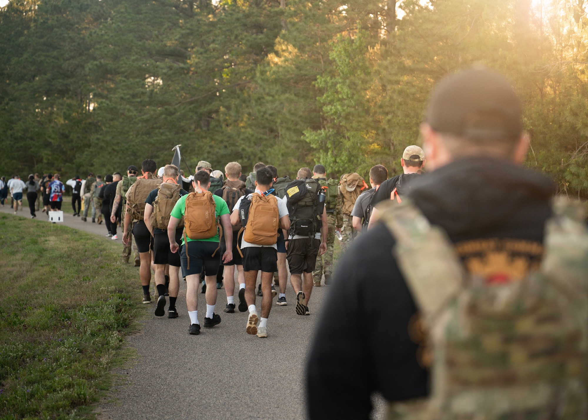 Airmen march while carrying backpacks