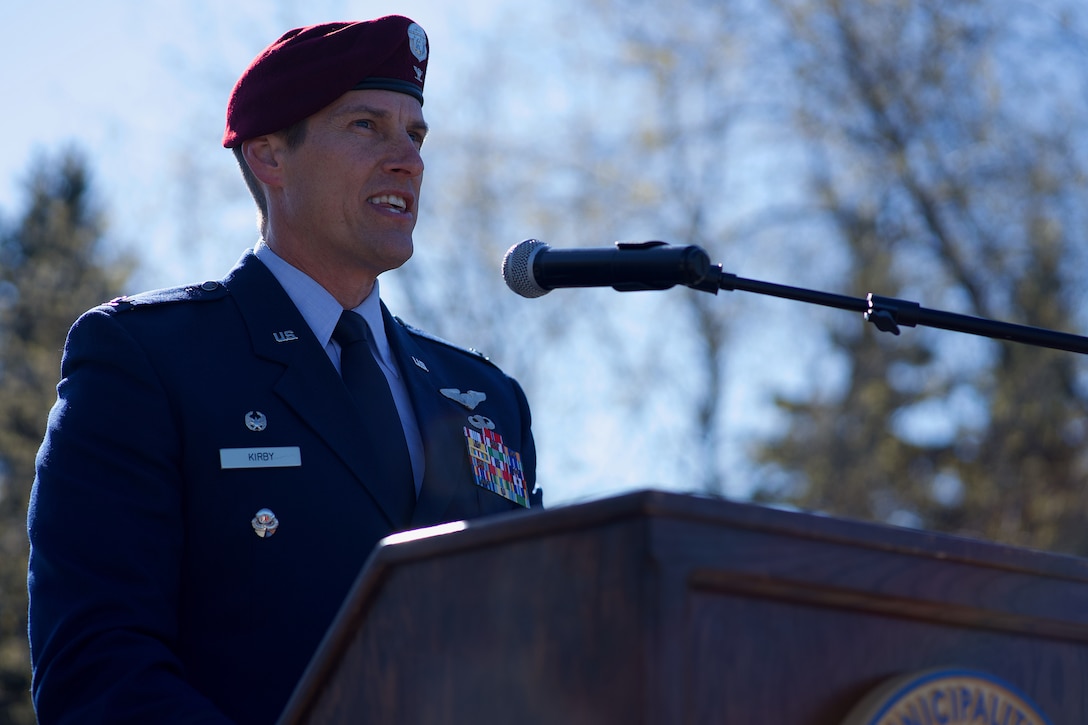 An Air Force officer speaks at a lectern outdoors.