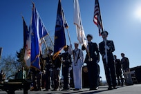 An Honor Guard presents U.S., Alaska, and military service colors.