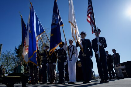 An Honor Guard presents U.S., Alaska, and military service colors.