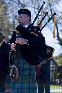 A bagpiper in full Celtic dress plays.