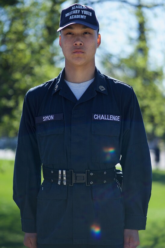 Cadet in blue uniform standing at attention.