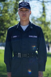 Cadet in blue uniform standing at attention.