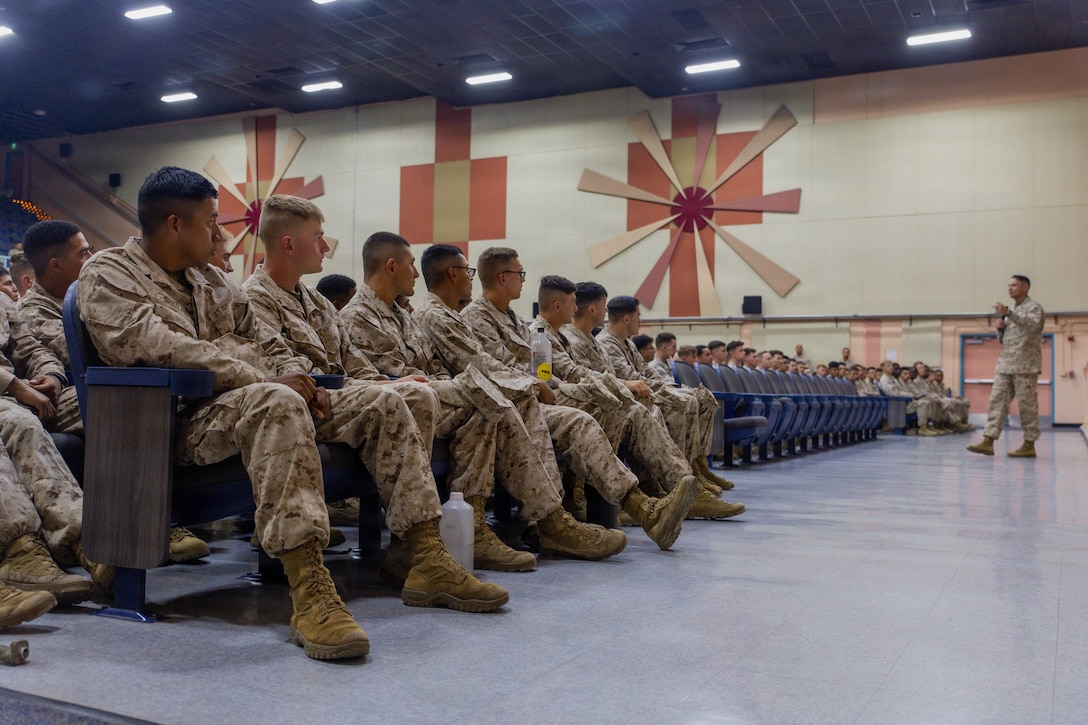 U.S. Marine Corps non-commissioned officers and junior Marines listen to Sgt. Maj. Carlos Ruiz, the 20th Sergeant Major of the Marine Corps, speak at the base theater, Twentynine Palms, California, May 7, 2026. By engaging directly with those living and working on base, Sgt. Maj. Ruiz is able to gain firsthand insight into the quality of life and the challenges presented by serving at a remote and isolated installation. (U.S. Marine Corps photo by Lance Cpl. Gracelyn Hanson)