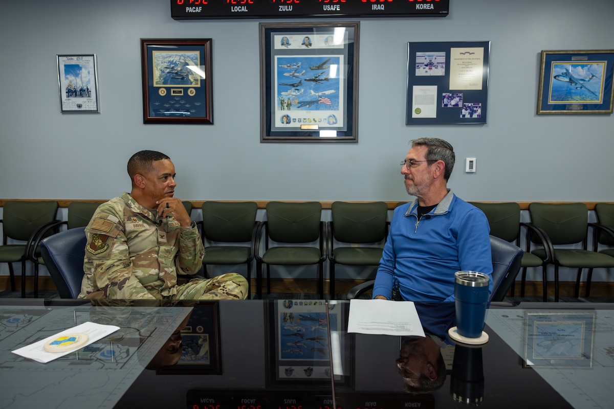 Two men sitting at a table talking