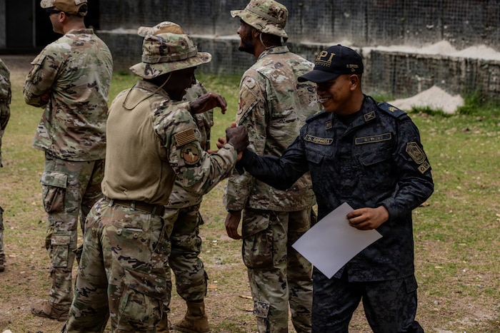 U.S. Airmen assigned to the 824th Base Defense Squadron, shake hands with a member of the Servicio de Protección Institucional during a graduation ceremony at Cerro Tigre, Panamá, April 17, 2026. U.S. Southern Command seeks to expand its ongoing coordination, collaboration, and security efforts where U.S. military personnel and Panamanian security institutions can bolster collective capabilities and skills, as well as facilitate a joint learning environment. (U.S. Army photo by Spc. Richard Morgan)