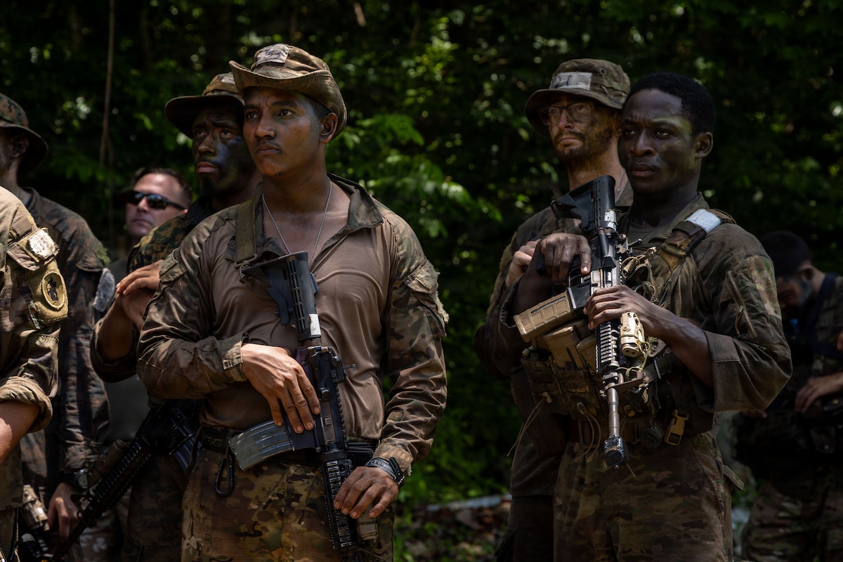 U.S. service members and Panamanian partners stand in formation while receiving instructions before the Green Mile event as part of the Jungle Operations Training Course–Panama at Aeronaval Base Cristóbal Colón, Panama, May 14, 2026. The training strengthens interoperability and reinforces the enduring partnership between U.S. forces and Panamanian security institutions through combined jungle operations and shared tactical experience. (U.S. Army photo by Sgt. Nirak Garcia Navarro)