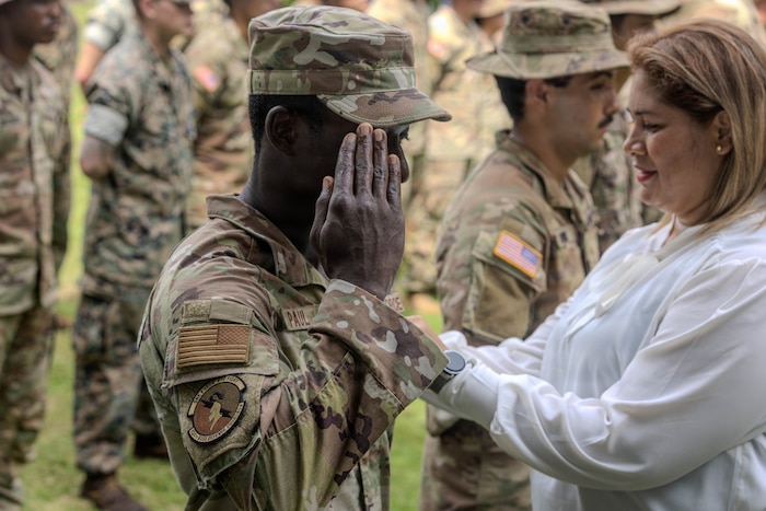 U.S. Air Force Staff Sgt. Duchaine Paul, assigned to the 824th Base Defense Squadron, is awarded the jungle tab on graduation day of the Jungle Operations Training Course - Panama at Aeronaval Base Cristóbal Colón, Panama, May 15, 2026. The 18-day course pushed participants to refine the skills needed to operate effectively in jungle environments while strengthening multinational interoperability. (U.S. Army photo by Spc. Richard Morgan)