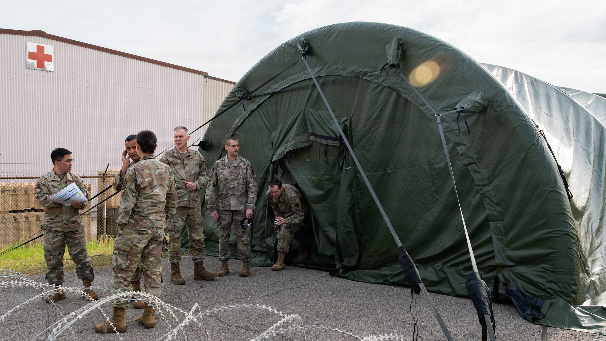 People talking in front of a tent.