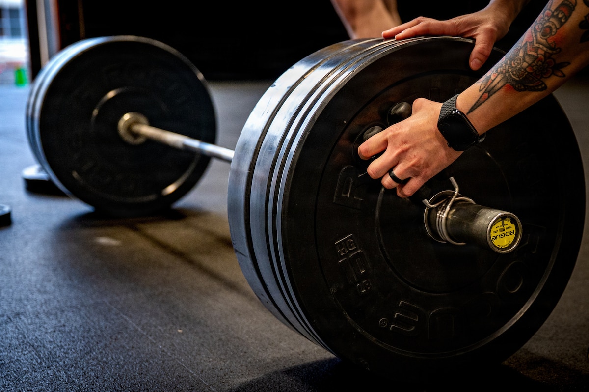 A participant adjusts weight plates during a dead lift event during the 2026 Sakura Olympics at Misawa Air Base, Japan, May 12, 2026. The annual event brings together U.S. Forces personnel, Japan Air Self-Defense Force members and their families through athletic competition, strengthening camaraderie, teamwork and community partnerships. (U.S. Air Force photo by Airman 1st Class Angelica Winther)