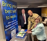 Barry Waite, Civilian Leadership Development School director; Col. Damien Holtzclaw, Air Force Global College commandant; and Glenda Scheiner, assistant deputy chief of staff for manpower, personnel and services, commemorate the strategic realignment of CLDS into AFGC during a ceremony at Maxwell Air Force Base, Alabama, April 20, 2026. (U.S. Air Force photo by Hayden Pickett)