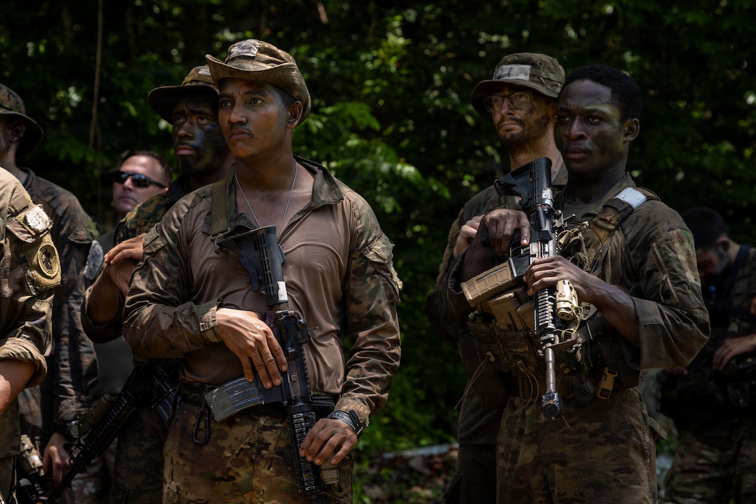 U.S. service members and Panamanian partners stand in formation while receiving instructions before the Green Mile event as part of the Jungle Operations Training Course–Panama at Aeronaval Base Cristóbal Colón, Panama, May 14, 2026. The training strengthens interoperability and reinforces the enduring partnership between U.S. forces and Panamanian security institutions through combined jungle operations and shared tactical experience. (U.S. Army photo by Sgt. Nirak Garcia Navarro)