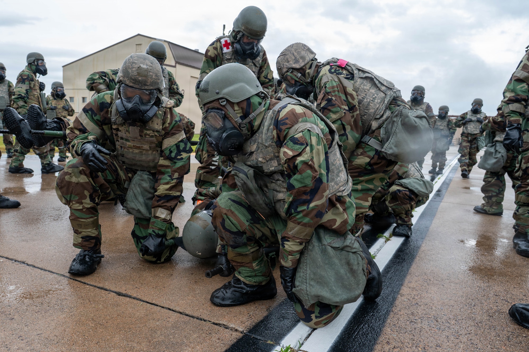 Airman load simulated patients onto a transport vehicle.